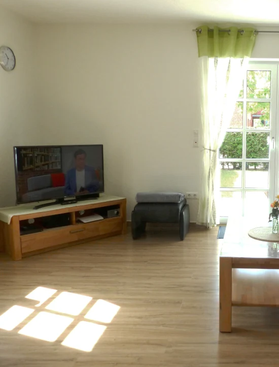 Wohnzimmer mit Sessel und TV