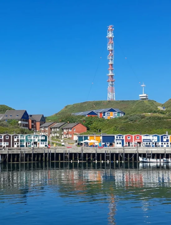 Blick auf bunte Häuser auf Helgoland vom Meer aus gesehen